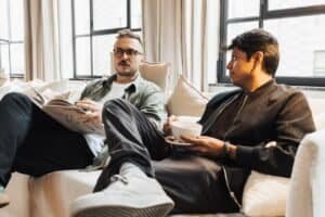 Two men talking on a couch about open relationships for gay couples